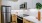 a kitchen with white cabinets and wood floors