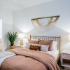 a bedroom with a nightstand, dresser and lamps