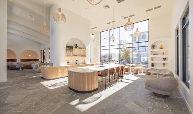 Cutting-edge amenities at your fingertips a clubhouse room with a large table and chairs