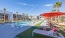 a pool with lounge chairs and umbrellas by it