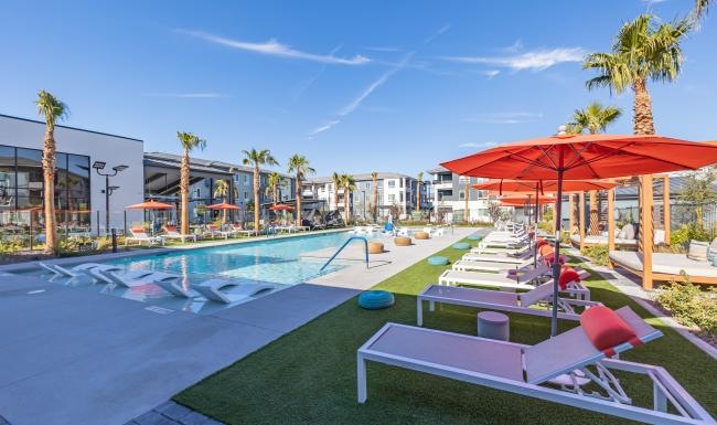 Resort-style swimming pool a pool with lounge chairs and umbrellas by it